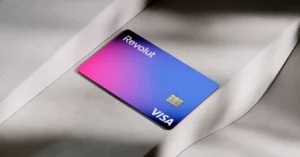 Cartão Revolut Visa em tons de azul e rosa sobre superfície clara.