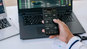 Pessoa acompanhando investimentos de renda variável no notebook e celular
